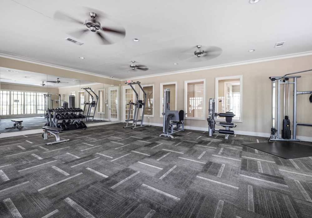 Well-equipped fitness center with treadmills and weight-lifting machines at Wembly At Overlook in Macon, Georgia