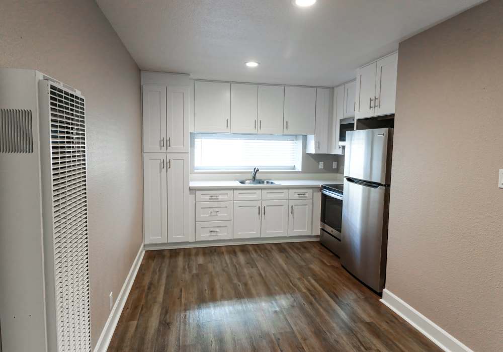 Kitchen with white appliances and open layout at Briarwood Apartments in Livermore, California