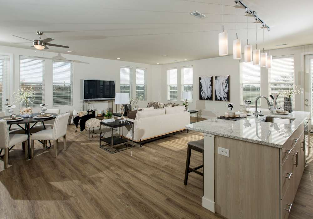 Cozy living room view from kitchen with hard-wood style flooring and hallway at Altair At The Heights in Richmond Heights, Missouri
