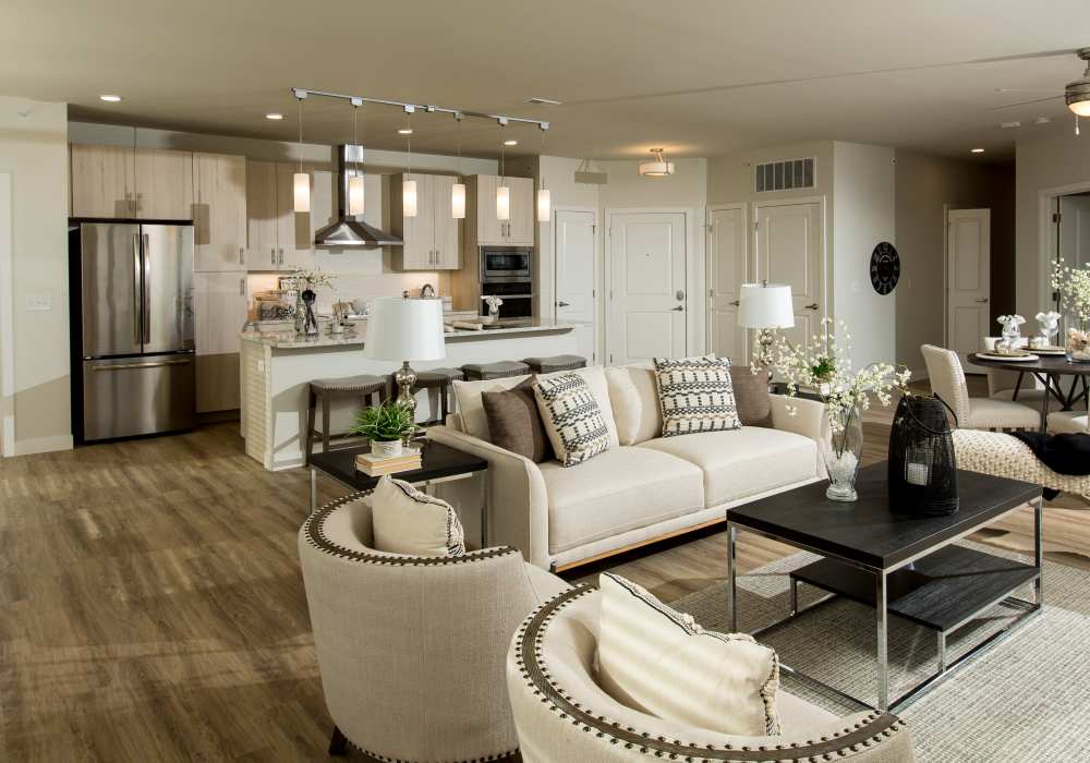 A cozy living room with a comfortable couch, a coffee table, and an open kitchen area at Altair At The Heights, Richmond Heights, Missouri