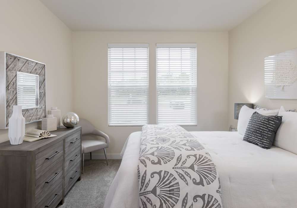 Cozy bedroom with dresser table at Altair At The Preserve in O'Fallon, Missouri