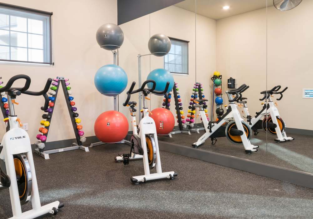 Fitness center with gym equipment's  with carpet flooring at Altair At The Preserve in O'Fallon, Missouri