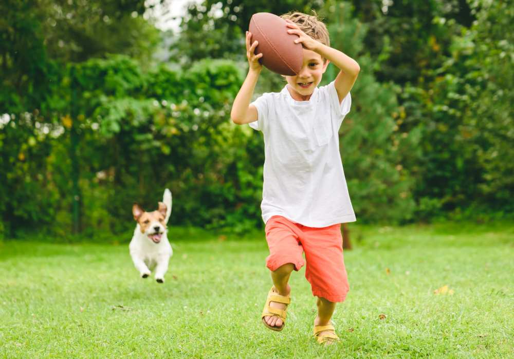 Small kid playing with his dog in a nearby dog park at Stonecreek Apartments in Katy, Texas 