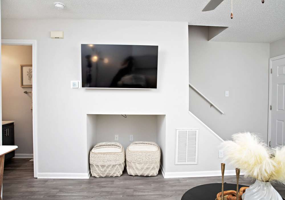 Living room with wood-style flooring and flat-screen TV at Edge at Concord in Concord, North Carolina, 