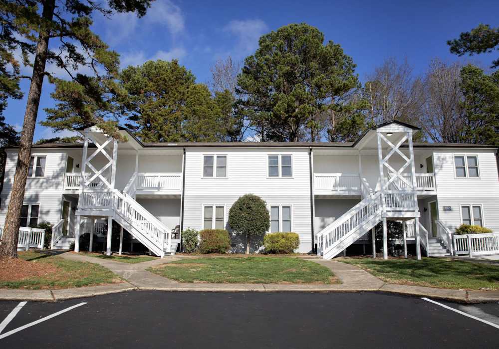 View of exterior of apartments and green lawn at Edge at Concord in Concord, North Carolina, 