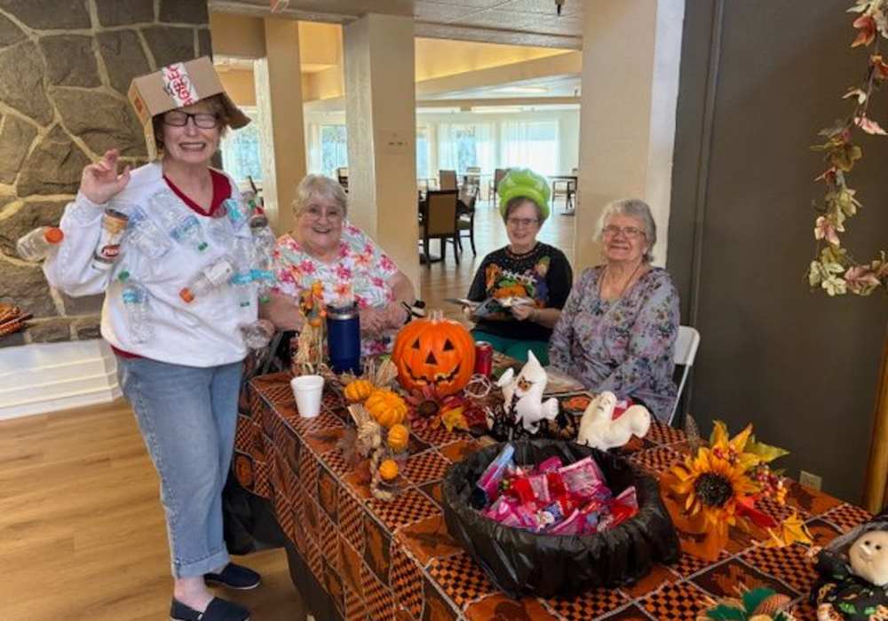 Residents sitting around a table with Halloween decor at Truewood by Merrill, Fig Garden in Fresno, California