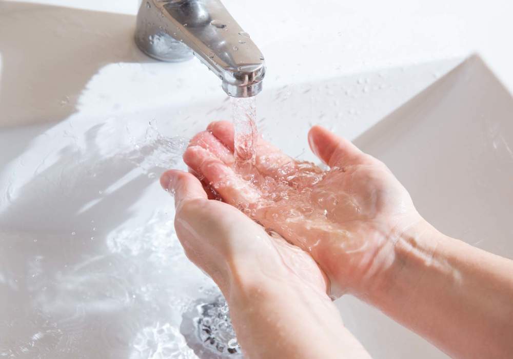 Resident washing hand in bathroom at Greer Mill Residences in Greer, South Carolina
