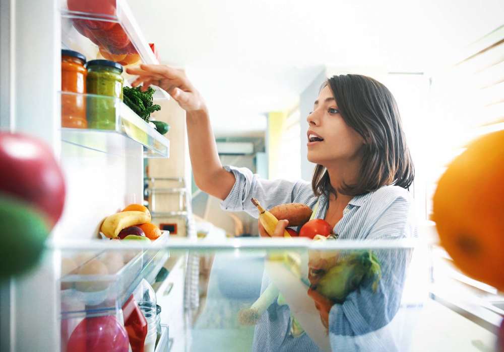 Resident taking fruits from refrigerator at Greer Mill Residences in Greer, South Carolina