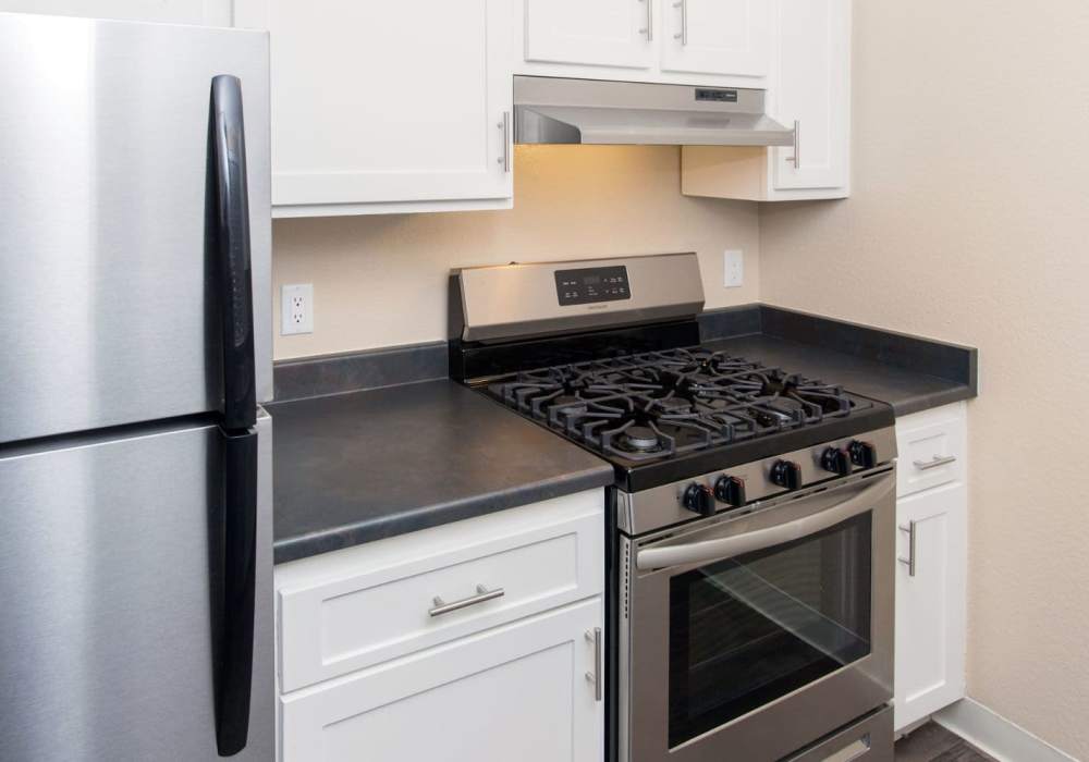 Kitchen with stainless-steel appliances and white cabinet at Amber Court in Fremont, California