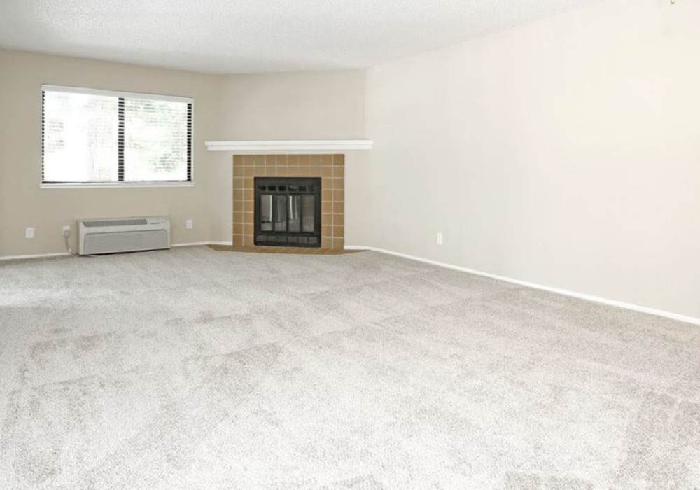Unfurnished living room with carpet flooring, fireplace and large window at Amber Court in Fremont, California
