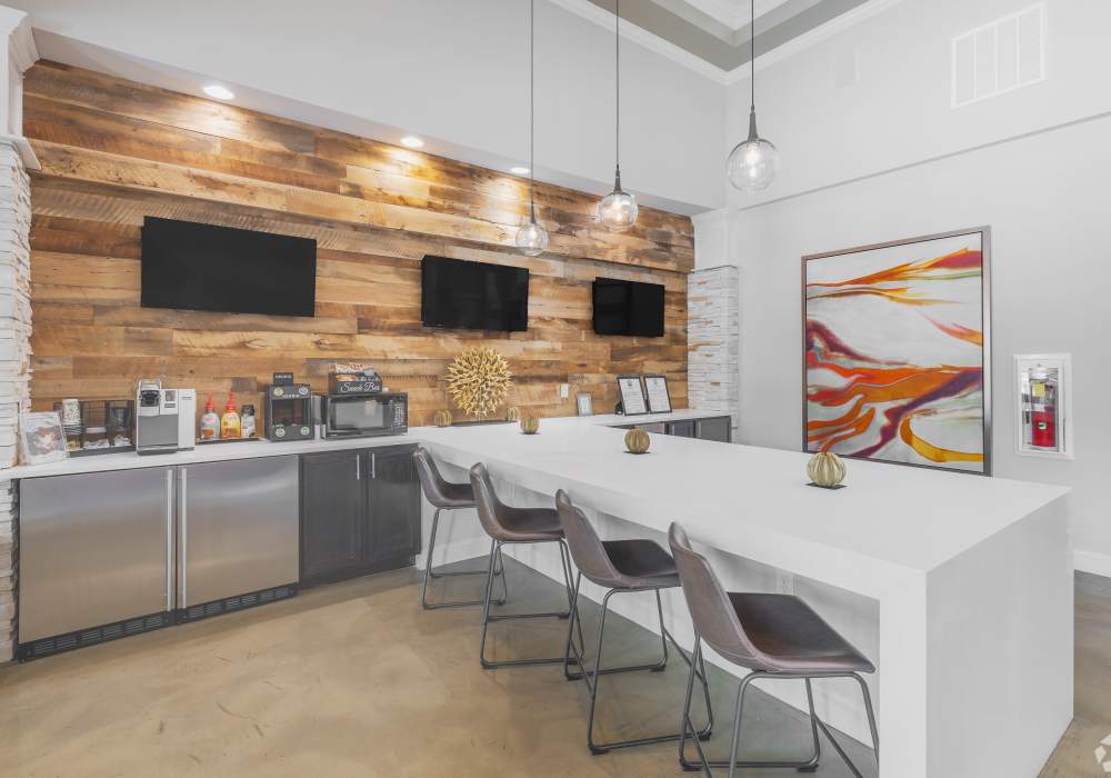 Resident lounge with bar seating and flat screen TVs at Harborstone in Ladson, South Carolina