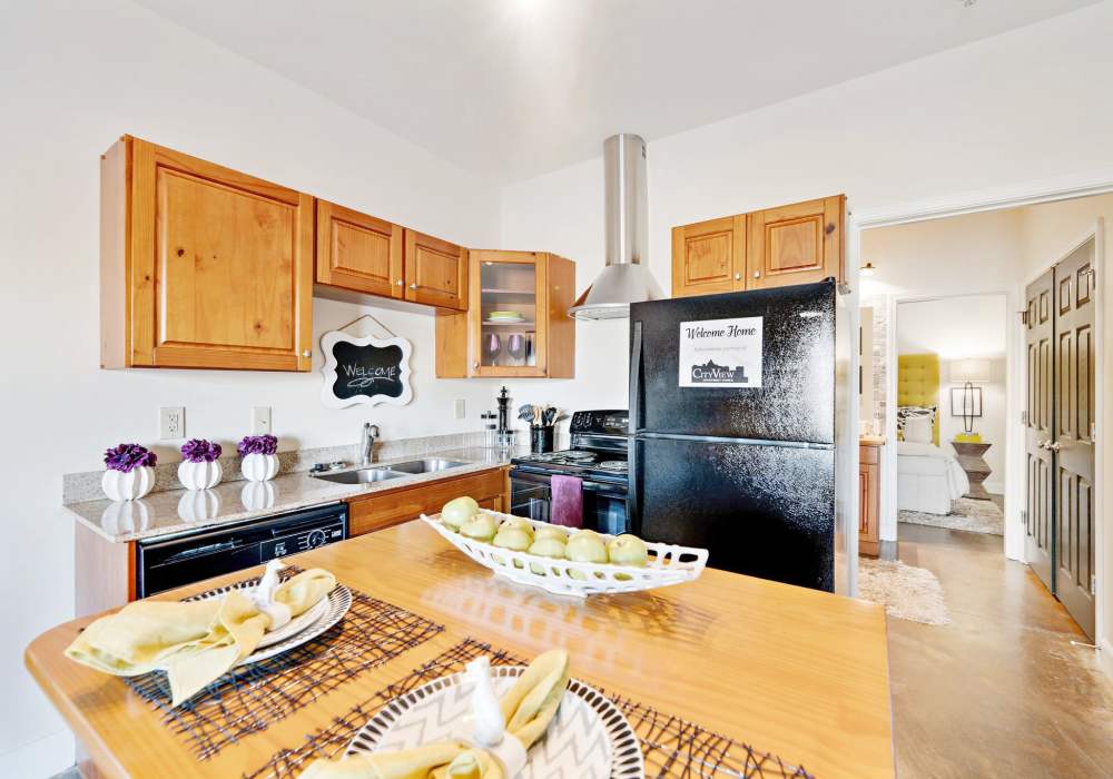 Kitchen with moveable island and bar stools, sleek black appliances with direct access to sliding glass doors to patio at CityView Apartments in Greensboro, North Carolina 