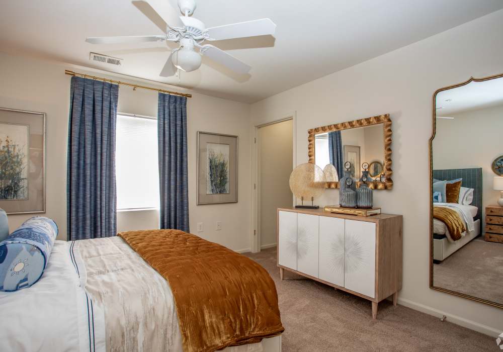 Bedroom with connecting bathroom, plush carpeting, large closets and a ceiling fan at Eagle Point Village in Fayetteville, North Carolina