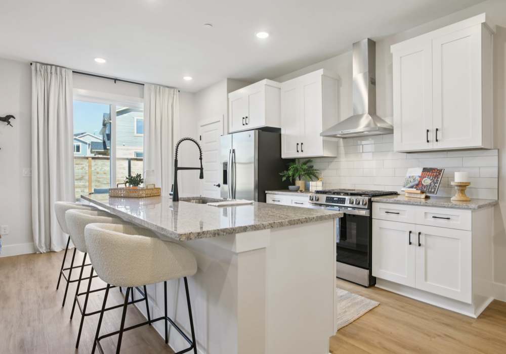 Kitchen with table counter top and high chairs at BB Living Sweetwater Crossing in Bee Cave, Texas