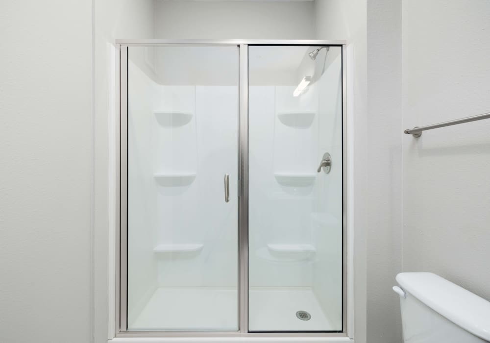 Shower area with glass sliding doors inside the bathroom at The Janson in Del Valle,Texas
