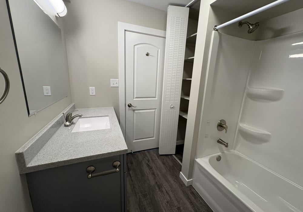 Bathroom with wooden flooring at Broadway Crossing Apartments in Merrillville, Indiana 
