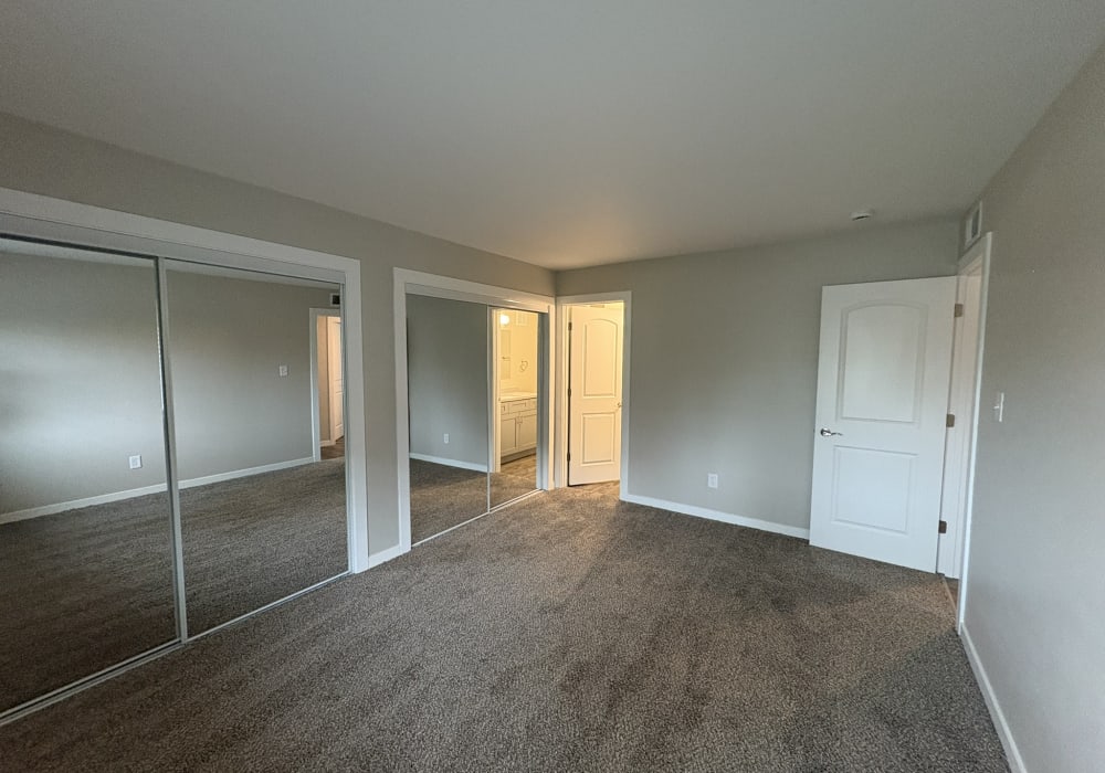 Unfurnished bedroom with carpet flooring and walking closet at Broadway Crossing Apartments in Merrillville, Indiana