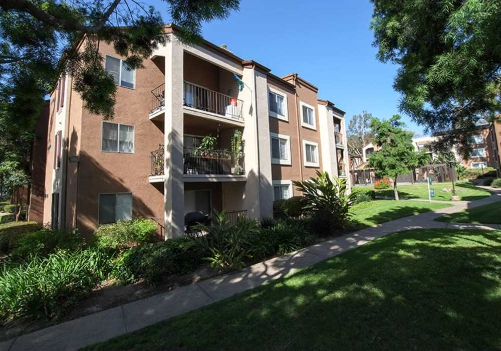 Charming apartment with lush landscaping and inviting balconies nestled in a tranquil community at River Run Village in San Diego, California