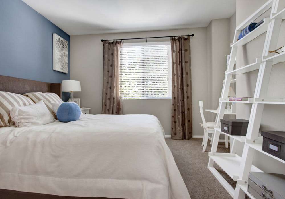 Well-lit bedroom with carpet flooring, large window at Rivers Edge in Lake Elsinore, California