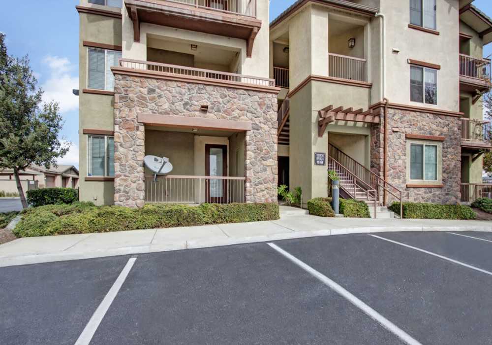View of exterior of apartments and green lawn at Rivers Edge in Lake Elsinore, California