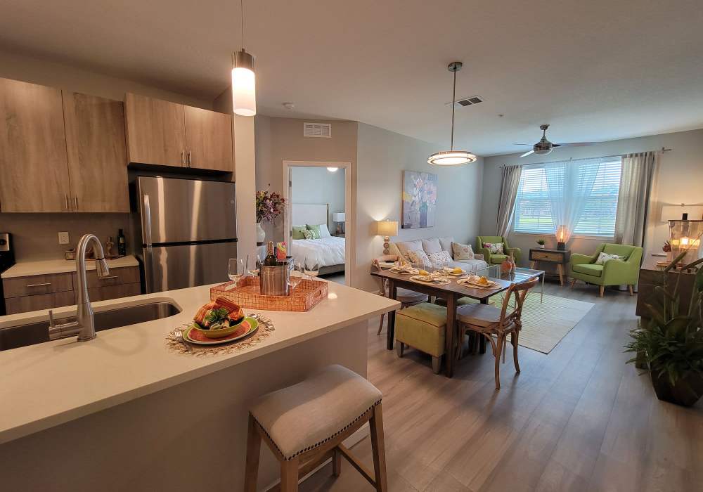 Modern kitchen with open living area and inviting dining space at Messina Luxury Apartments in New Smyrna Beach, Florida