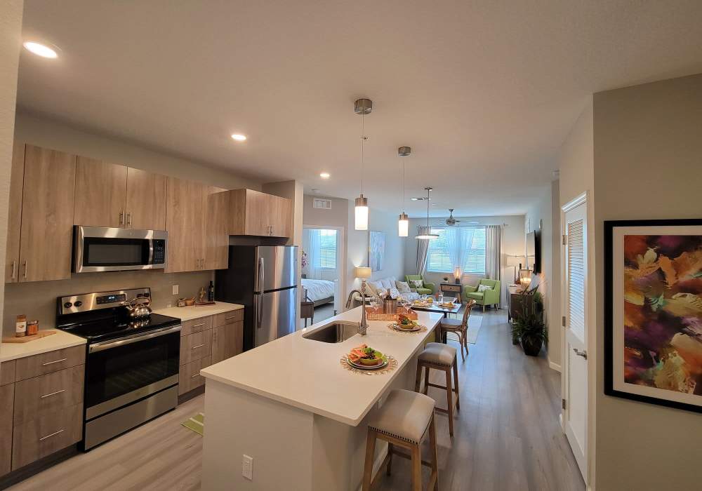 Modern kitchen with open living space and elegant dining area at Messina Luxury Apartments in New Smyrna Beach, Florida