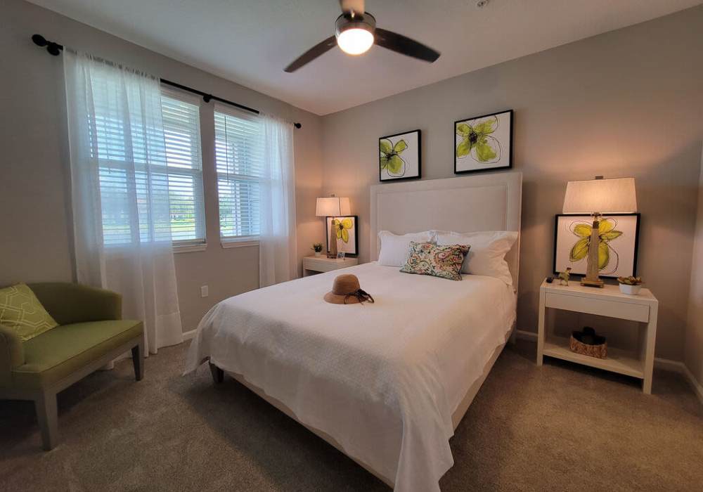 Cozy bedroom with soft lighting and botanical decor at Messina Luxury Apartments in New Smyrna Beach, Florida