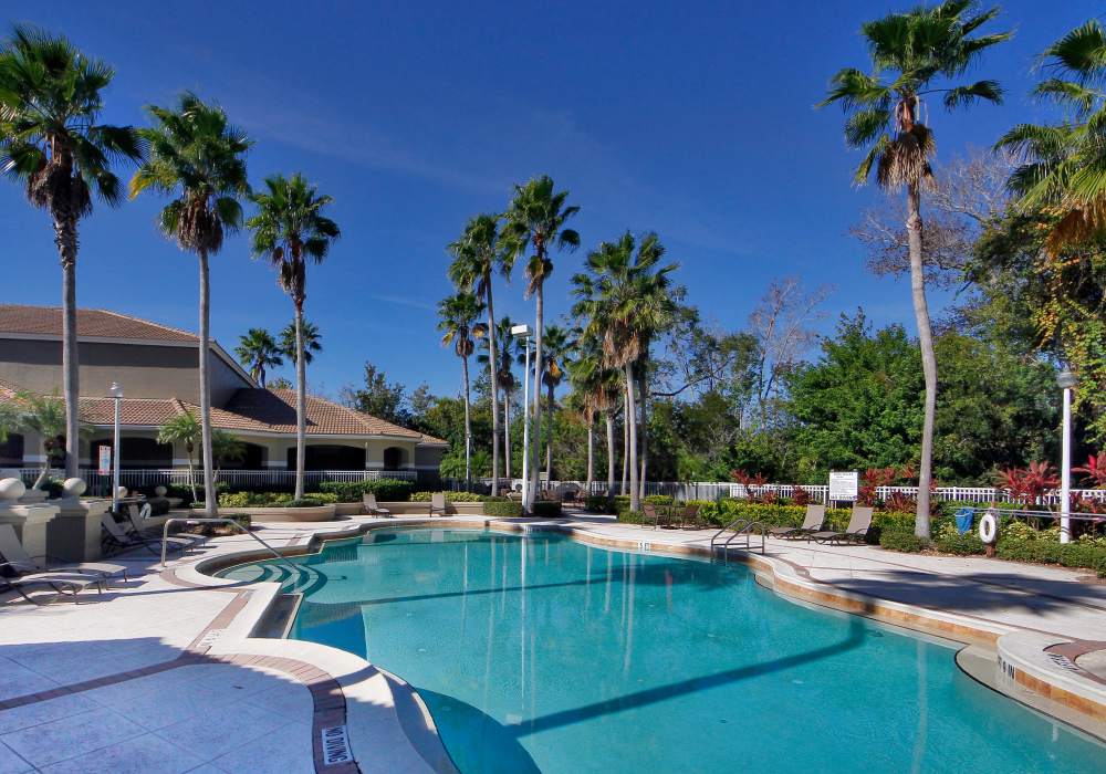 Swimming pool with lounge chairs at Via Tuscany Apartments in Melbourne, Florida