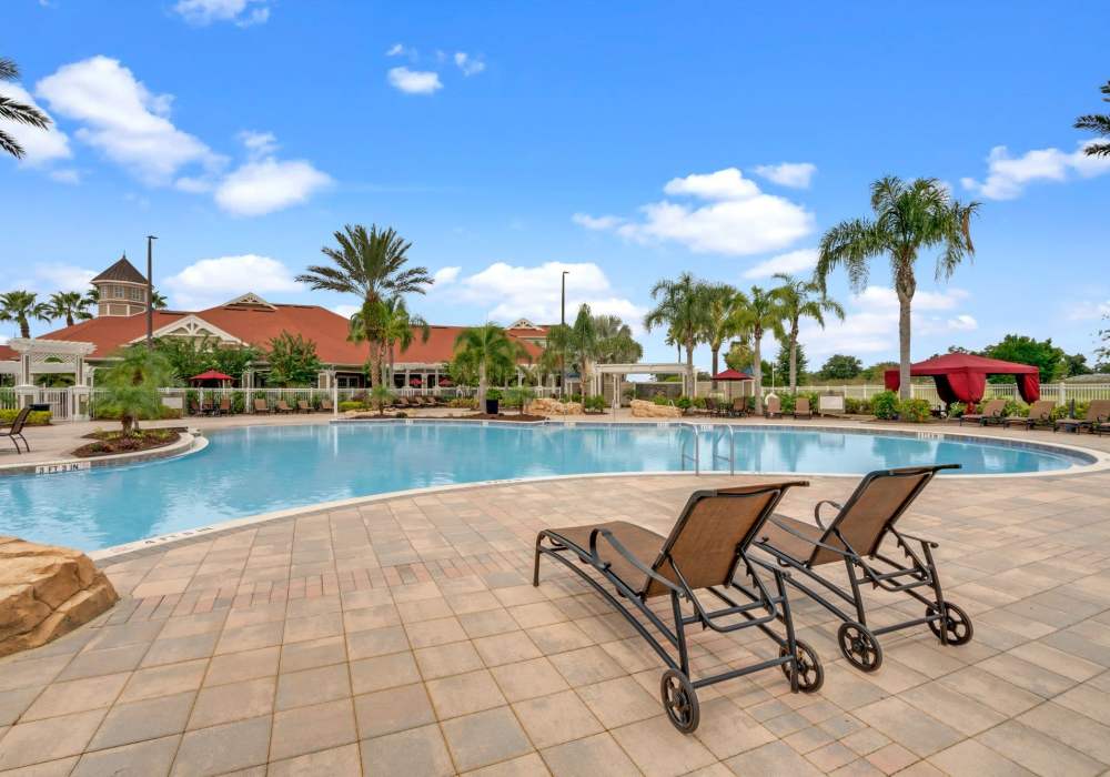 Swimming pool with lounge beds at Victoria Park Apartments in Davenport,Florida