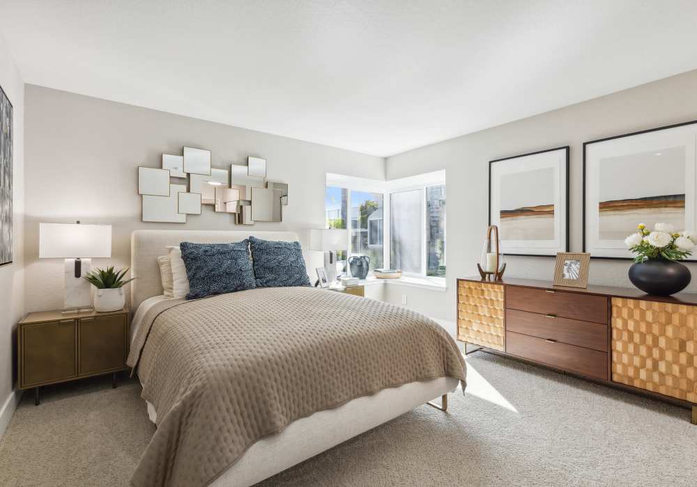 Well-furnished bedroom with carpet and large windows for tons of natural light in a model home at Sofi at Wood Ranch in Simi Valley, California
