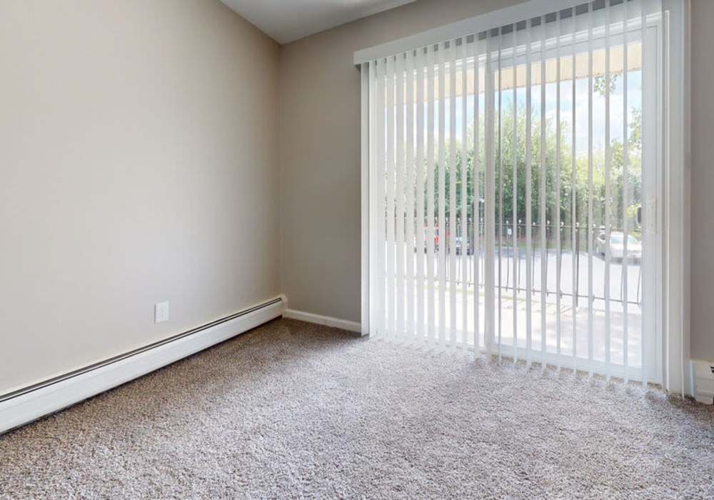 Spacious living room with attached patio at Broadway Crossing Apartments in Merrillville, Indiana