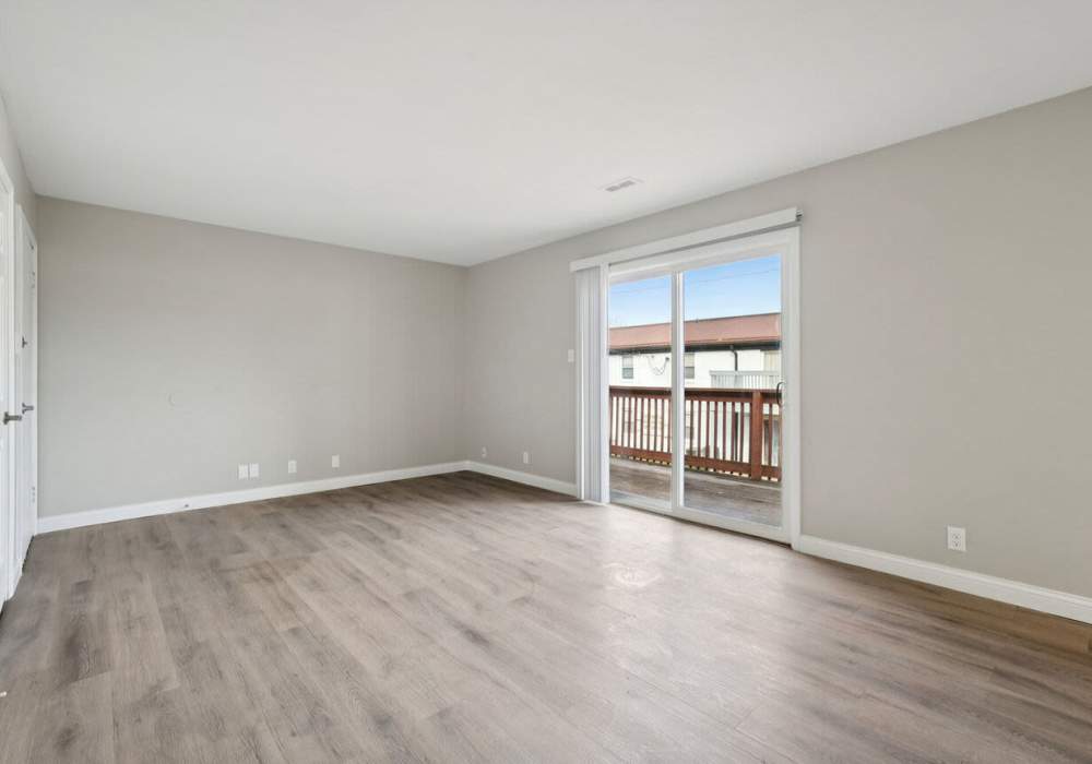 Living room with balcony access at Charleston Square Apartments in Columbus, Indiana