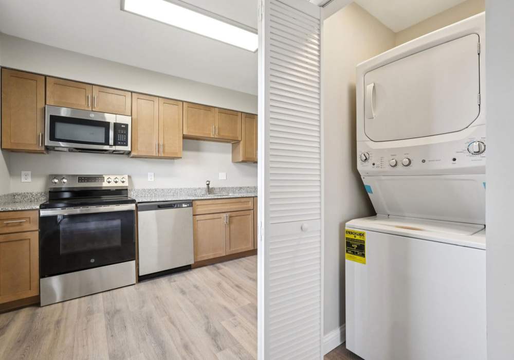 Kitchen with wooden cabinets and apartment laundry at Charleston Square Apartments in Columbus, Indiana