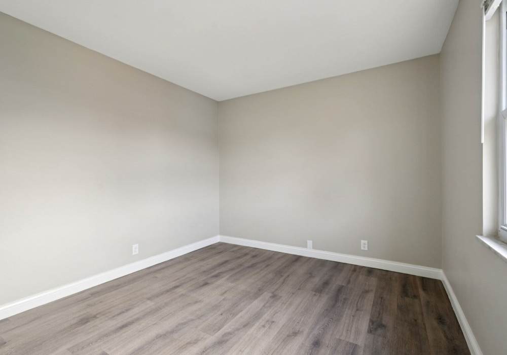 Unfurnished bedroom with wooden flooring and good lighting at Charleston Square Apartments in Columbus, Indiana