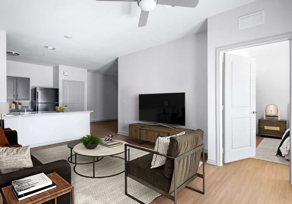 Modern living room with TV and kitchen view at Terrace at Southern Oaks in Dallas, Texas
