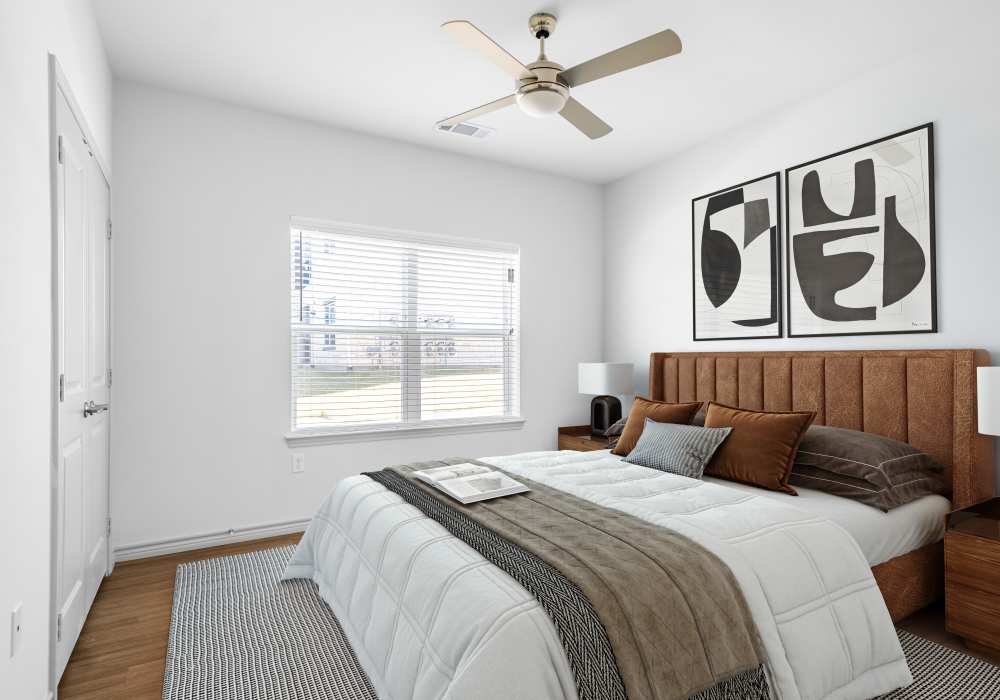 Cozy bedroom with large window and modern decor at Terrace at Southern Oaks in Dallas, Texas
