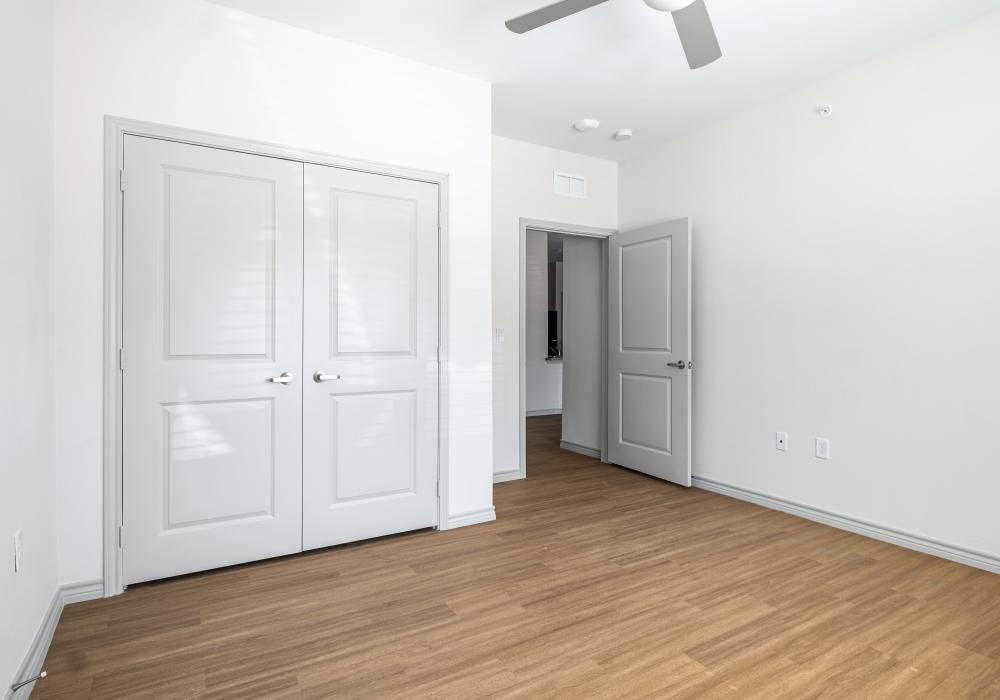 Bedroom with double doors and wooden floor at Terrace at Southern Oaks in Dallas, Texas