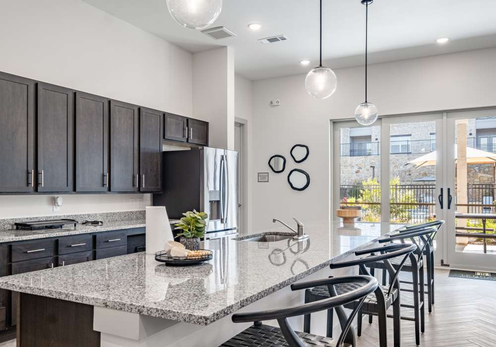 Modern kitchen with granite countertops and stainless appliances in the clubhouse at Terrace at Southern Oaks in Dallas, Texas