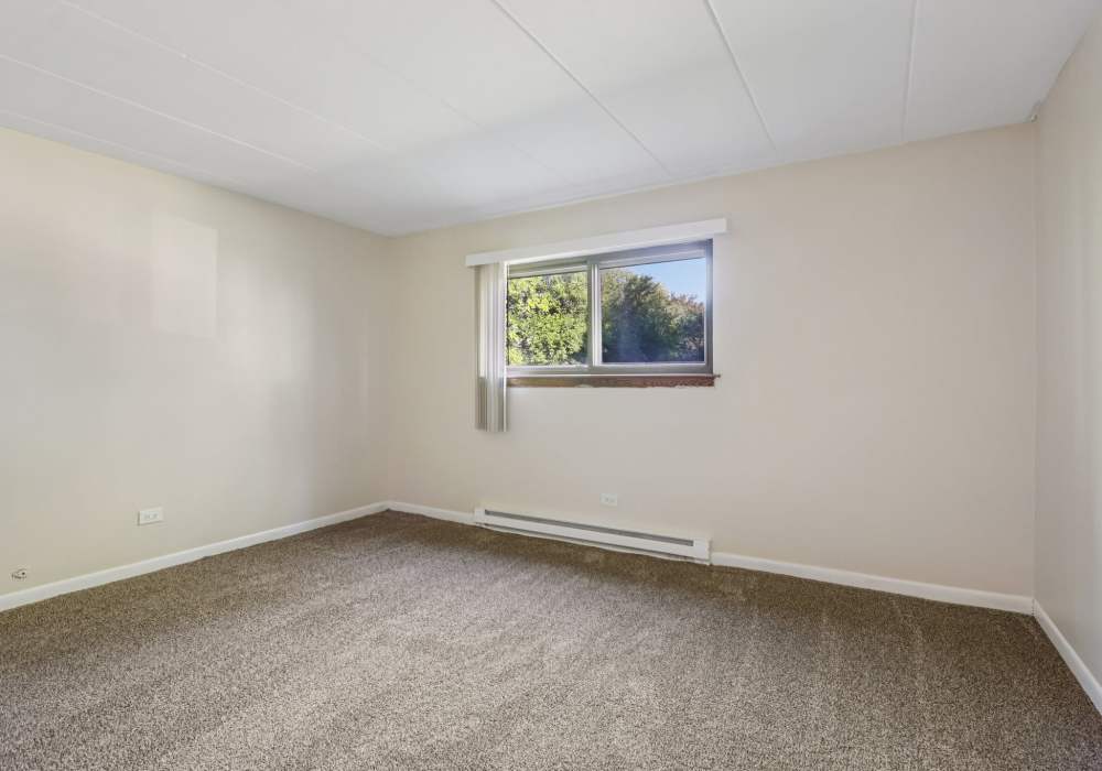 Bedroom with plush carpeting at Regents Park Apartments in Bensenville, Illinois