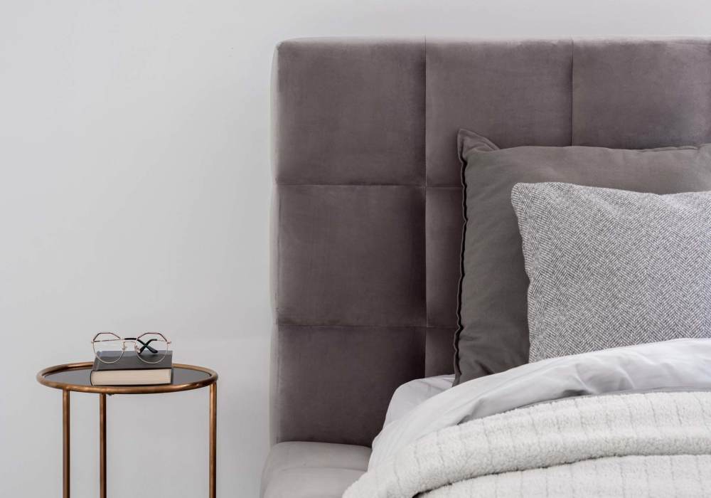 Stylish bedroom with plush bedding and elegant nightstand at Standard at Royal Lane in Dallas, Texas