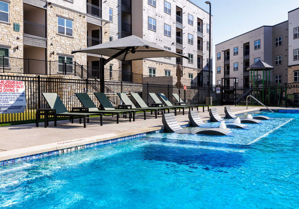 Swimming pool with sun loungers at Preserve at Gresham Lake in Raleigh,North Carolina