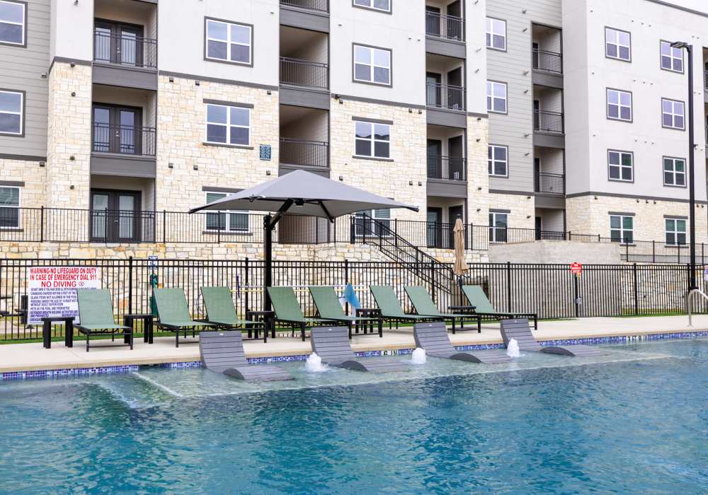 Community pool with lounge chairs at Preserve at Gresham Lake in Raleigh,North Carolina