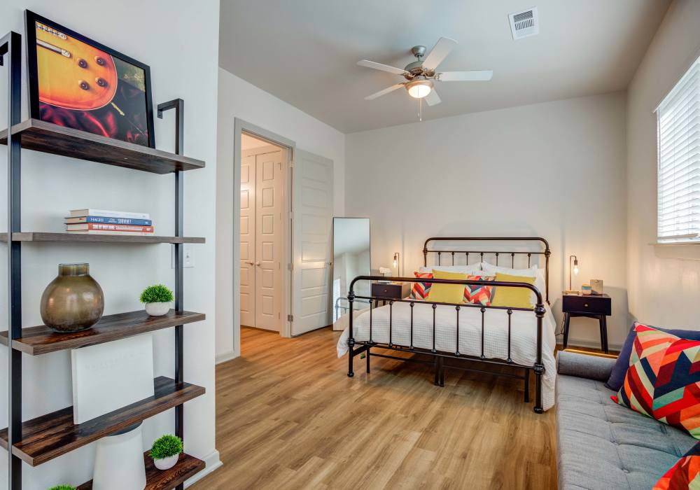 Bedroom with ceiling fan in a model home at The Rail Apartments in Austin, Texas