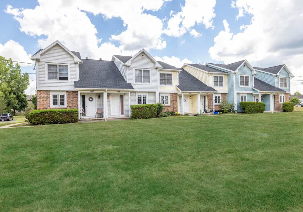 Townhome community exterior with landscaped lawn at North Road Townhomes in Scottsville, New York