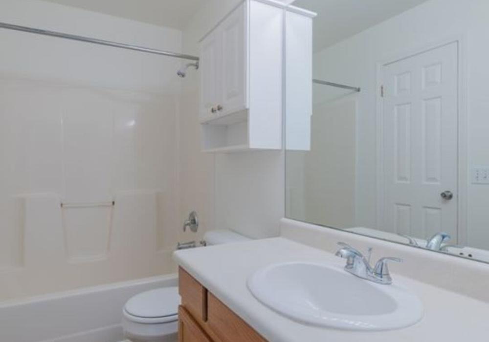 Bathroom with a mirror, and bathtub at North Road Townhomes in Scottsville, New York