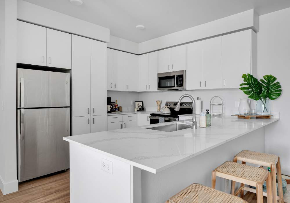 Kitchen with granite countertops, stainless steel appliances, and wood-style flooring at Tilian Point in Woodburn, Oregon
