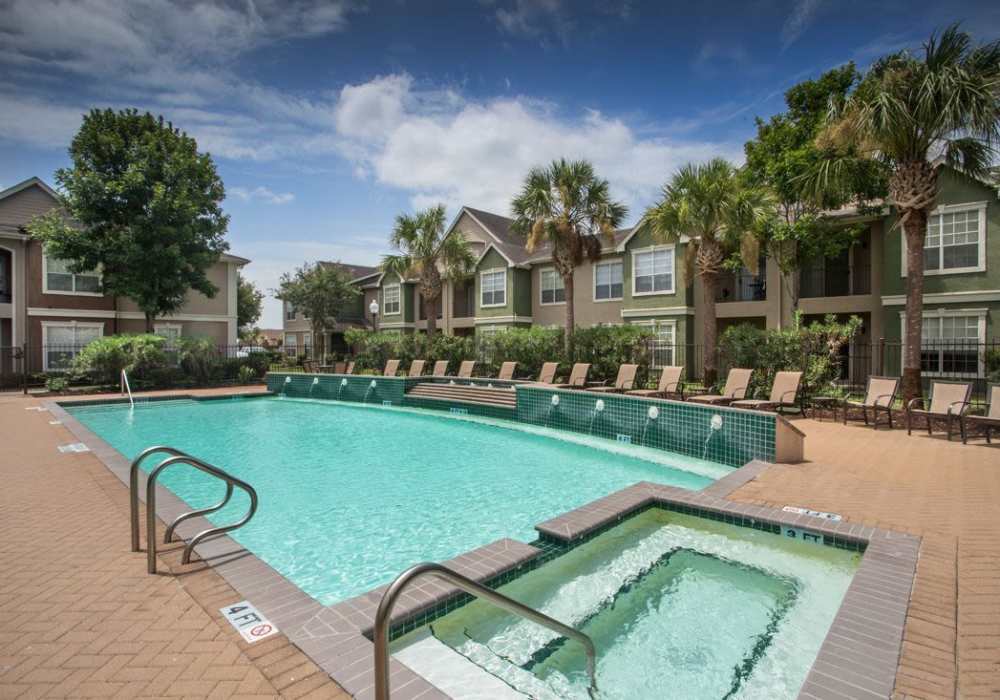 Swimming pool with lounge chairs at Reata Apartments in Harlingen, Texas