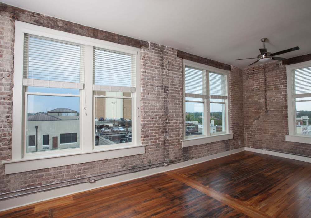 Large windows with blinds and exposed brick at Hub City Lofts in Hattiesburg, Mississippi