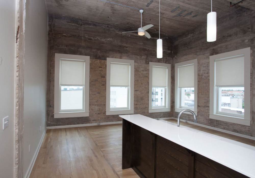 Exposed brick walls and large windows at Hub City Lofts in Hattiesburg, Mississippi
