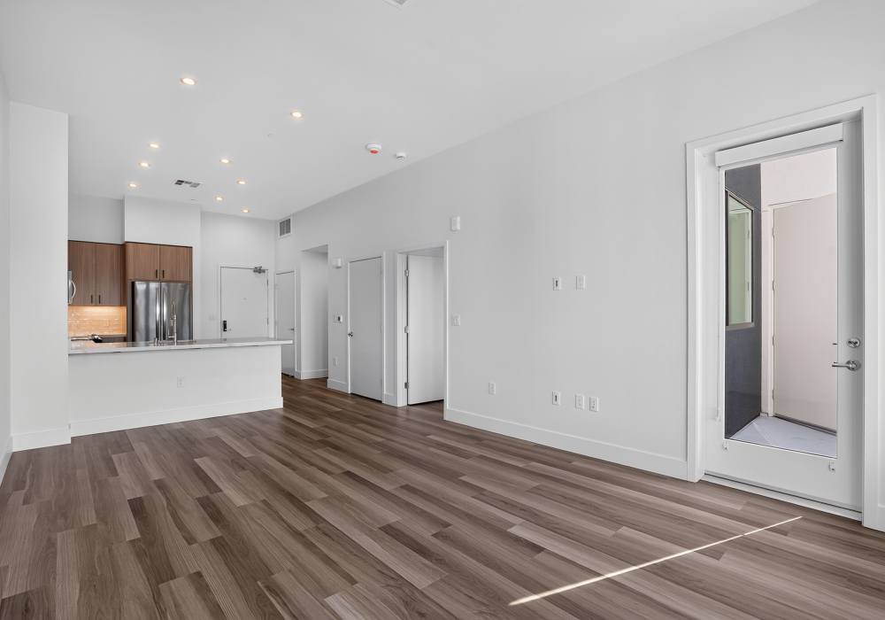 Open living area with breakfast bar, kitchen and door to private patio at The Colton in Redwood City, California